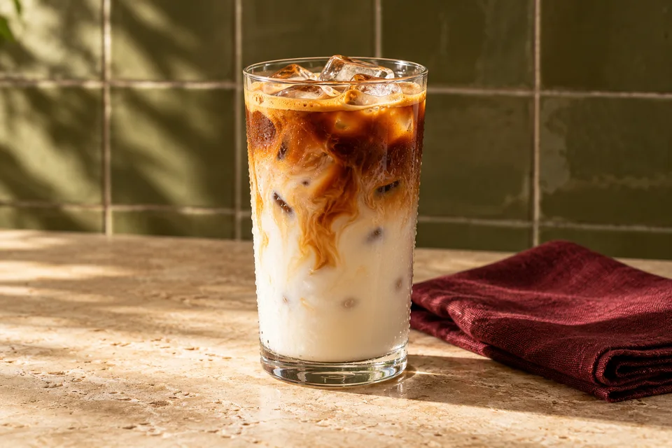 Iskaffe med mælk, isterninger og espresso i et højt glas